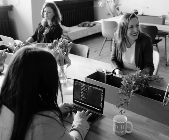 women coding around a desk